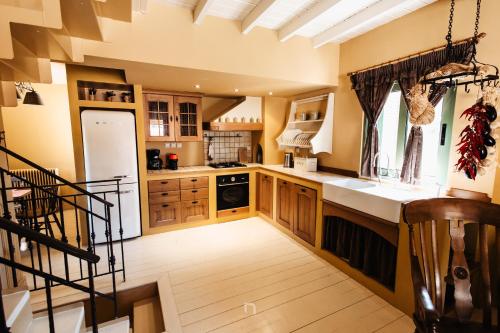 a large kitchen with wooden cabinets and a staircase at Kalavryta Estate Villa in Kalavrita