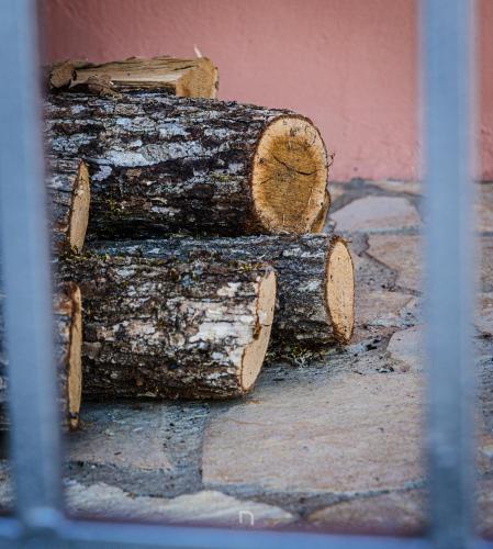 a pile of logs sitting next to a building at Kalavryta Estate Villa in Kalavrita