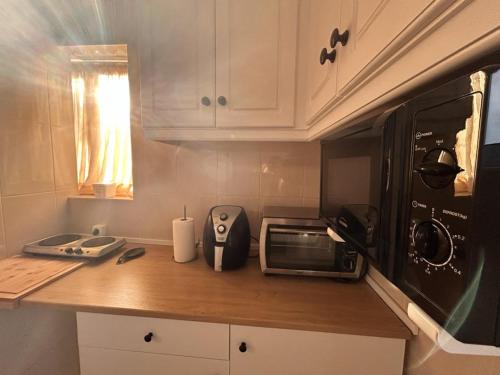 a kitchen with a counter top with a microwave at Casinha Margarida in Adaúfe
