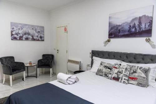 een slaapkamer met een bed en twee stoelen bij Natalie's Inn in Belgrado