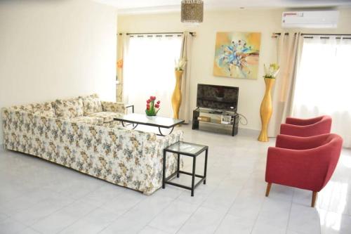 a living room with a couch and two chairs at Atlantika, Clim, Fidjrossè Plage in Cotonou