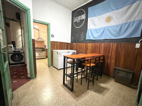 a kitchen with a table and a flag on the wall at Lacandona Hostel in Cordoba