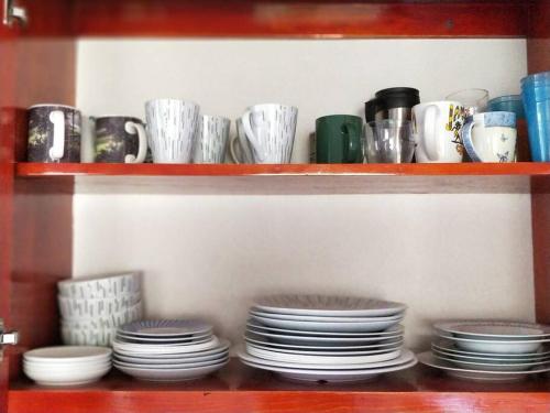 a shelf full of plates and cups and bowls at Wild Blue Lodge in Gwa Kay