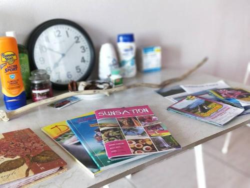 a table with magazines and a clock on it at Wild Blue Lodge in Gwa Kay