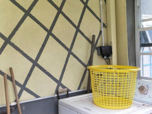 a yellow basket sitting on top of a washing machine at Wild Blue Lodge in Gwa Kay