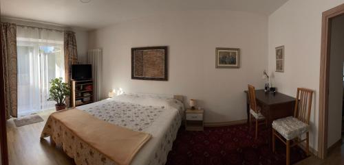 a bedroom with a bed and a desk and a window at MiniLevico in Levico Terme