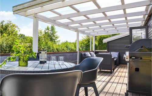 a patio with a table and chairs under a pergola at 2 Bedroom Amazing Home In Kirke Såby in Kirke Såby