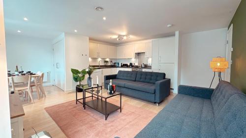 a living room with a blue couch and a table at Shoreditch Britannia Apartments in London