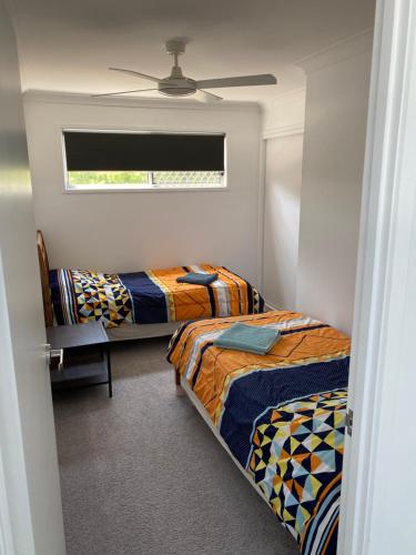 a bedroom with two beds and a window at 2BD Family or Couple Guesthouse Upstairs near Turf club, HOTA in Bundall in Gold Coast