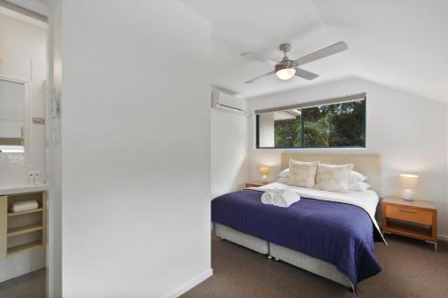 a bedroom with a bed and a ceiling fan at Gosamara Apartments in Byron Bay