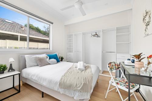 a white bedroom with a bed and a desk at Elegant Double Room at Botany - Mins to Airport - Shared Bathroom in Sydney