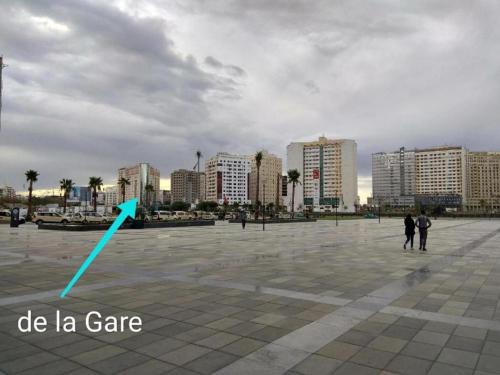 a blue arrow pointing to a city with buildings at appartement 22 in Tangier