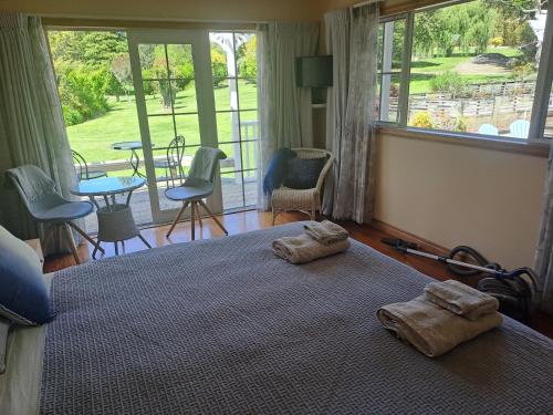 a bedroom with a bed with two towels on it at Keriwin House in Kerikeri