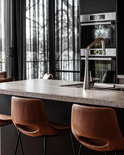 a kitchen with a counter with chairs and a sink at Deviot Boat House in Deviot