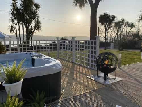 a hot tub sitting on a deck next to a fence at Seaview Cottage on the Island in Millbay