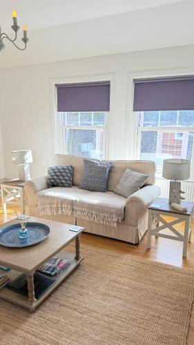 a living room with a couch and a table at Harbour Retreat Padstow - Entire Apartment in the beautiful old town of Padstow Harbour in Padstow