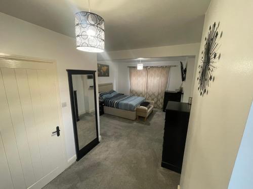 a bedroom with a bed and a mirror and a door at Welcome rooms 54 in Swindon