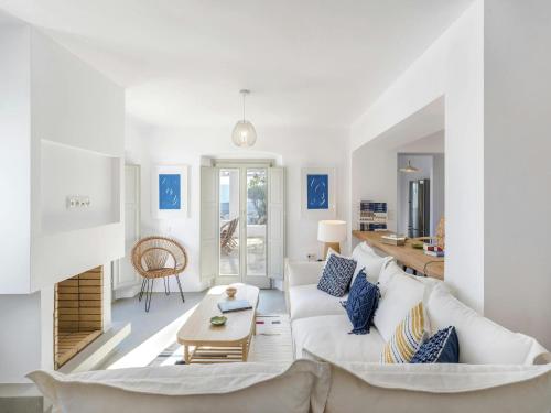 un soggiorno con un divano bianco e un tavolo di Stunning villa with modern decor a Agios Sostis