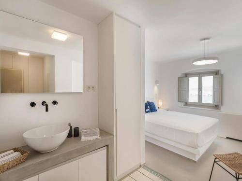 bagno bianco con lavandino e letto di Stunning villa with modern decor a Agios Sostis