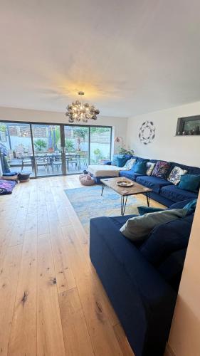 a living room with a blue couch and a table at Tregenna House - St Ives, A Beautiful Newly Refurbished 4 Bedroom Family Town House With Alfresco Dining Garden and Private Parking Spaces in St Ives