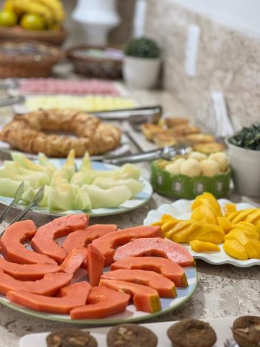 a table topped with plates of fruits and vegetables at Pousada Maré de Bombas in Bombas