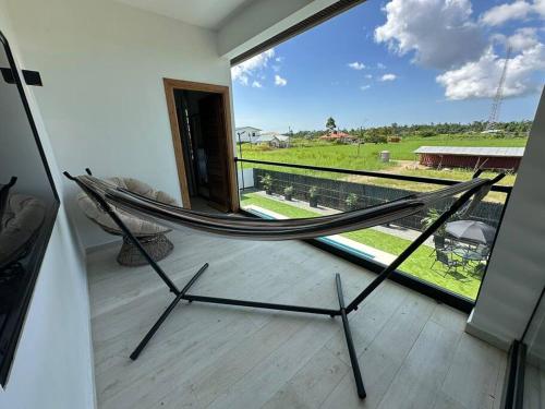 a hammock on a balcony with a view of a field at Casa Tua Suriname New 4 bedroom Townhouse 14B in Paramaribo