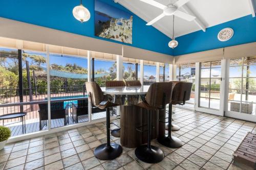 a living room with a table and chairs and a pool at Chenu Lakeside Homestead in Eagle Point