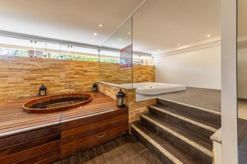 a bathroom with a tub and a sink and stairs at Barra Bali Beach in Barra de São Miguel