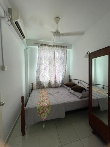 a bedroom with a bed with a window and a fan at Helya Homestay Wakaf Che Yeh in Kota Bharu