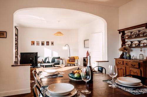 Un comedor con una mesa con platos y copas de vino. en Après la ballade, le réconfort!, en Champagne-sur-Seine