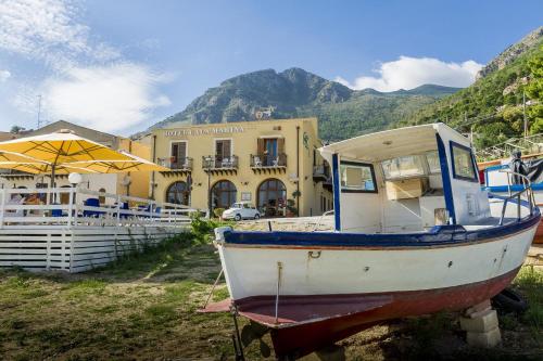 a boat sitting on the ground in front of a building at Hotel Cala Marina in Castellammare del Golfo