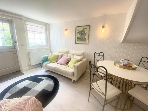 a living room with a couch and a table at Stylish Cottage with Quay and River View in Lymington