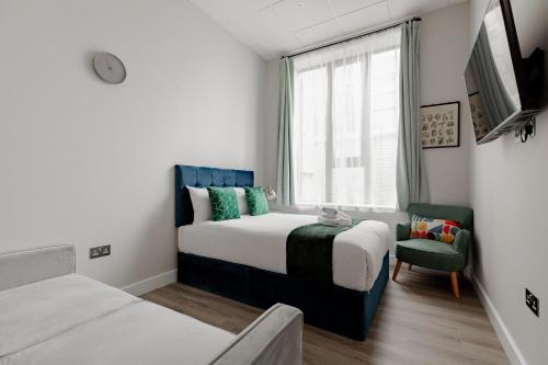 een slaapkamer met een bed, een stoel en een raam bij Hyde Park Studios in Londen