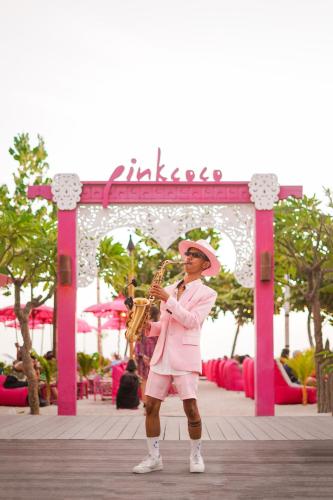 a man playing a saxophone in front of a gate at PinkCoco Gili Trawangan - Constant Surprises - for Cool Adults Only in Gili Trawangan