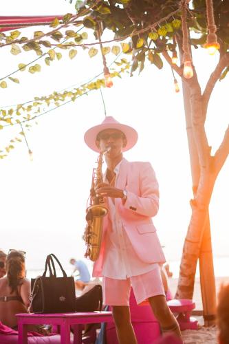 a man playing a saxophone on the beach at PinkCoco Gili Trawangan - Constant Surprises - for Cool Adults Only in Gili Trawangan