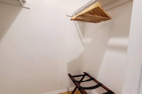 a wooden chair in a room with a white wall at Centrally located in Rogers and Bentonville! -Private Rooms in Rogers