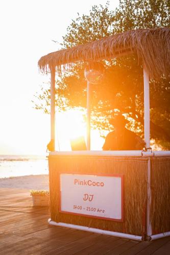 a kiosk on the beach with a sign on it at PinkCoco Gili Trawangan - Constant Surprises - for Cool Adults Only in Gili Trawangan