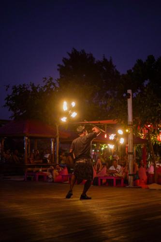 a man holding a box on his head at night at PinkCoco Gili Trawangan - Constant Surprises - for Cool Adults Only in Gili Trawangan