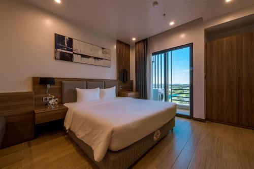 a bedroom with a large bed and a large window at ZEN RIVERSIDE HOTEL & RESIDENCES in Hai Phong