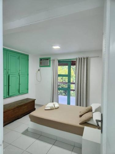 a bedroom with a large bed and a window at Casa Paraíso Bananal - Iha Grande - Angra Dos Reis in Angra dos Reis