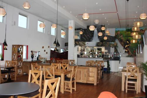 ein Restaurant mit Tischen und Stühlen und eine Bar in der Unterkunft Desalis Hotel London Stansted in Elsenham
