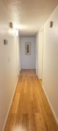 an empty hallway with a wooden floor in an apartment at Centrally located in Rogers and Bentonville! -Private Rooms in Rogers