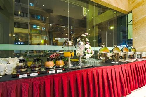 uma mesa com tigelas e jarras sobre uma mesa vermelha em Lazdana Hotel Kuala Lumpur em Kuala Lumpur