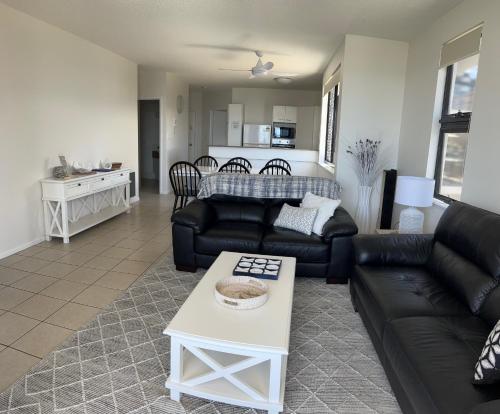 a living room with a couch and a table at Kings Row Apartments in Caloundra
