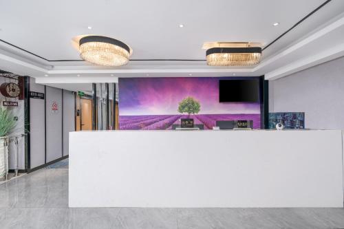 a lobby with a white counter and a tv at Yi Nuo Hotel Guangzhou in Guangzhou