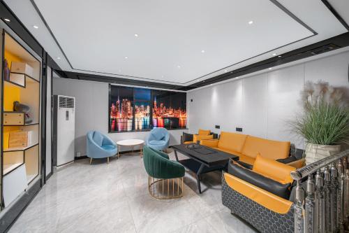 a living room with a couch and a table and chairs at Yi Nuo Hotel Guangzhou in Guangzhou