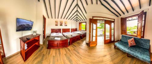 a living room with two beds and a couch at Hotel Campestre Villa Salome in Quimbaya
