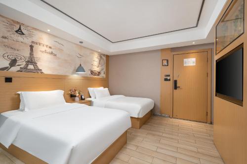 two beds in a hotel room with a tv at Yi Nuo Hotel Guangzhou in Guangzhou