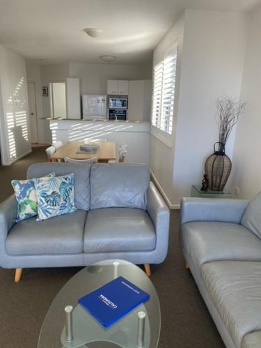 a living room with a couch and a table at Kings Row Apartments in Caloundra