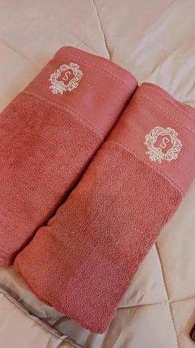 un par de toallas rojas sentadas en una cama en Northpoint CozyHome, en Davao City